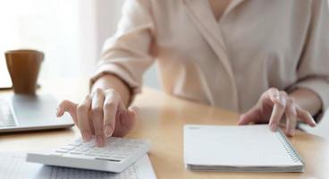 Woman using calculator and laptop photo