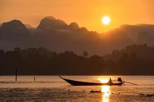 Silhouette image of a  boat sailing in a dam in southern of Thailand