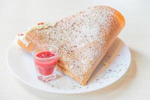 Postre crepe con frutas de fresa y nata montada foto