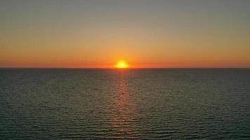 Sun setting behind the horizon line photo