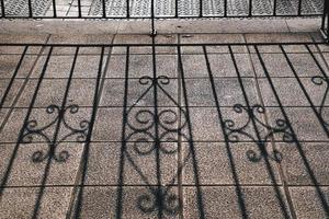 Shadows of the metallic fence on the ground photo