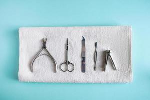Herramientas para manicura y cuidado de uñas sobre fondo azul. foto
