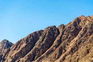 Peaks of rocky mountains against a blue sky in Egypt photo