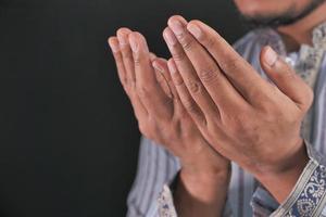 Man's hands praying on black background photo
