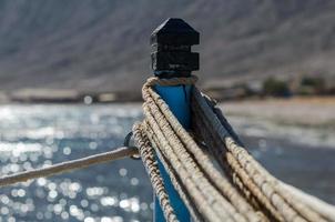 cuerdas en un poste contra el mar azul foto