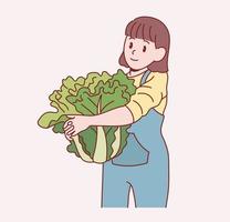 A cute little girl is standing holding a large cabbage. Hand drawn style vector design illustrations.