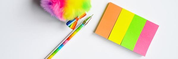 Multi-colored stickers and a pen on white background photo