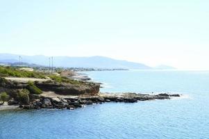 hermosa laguna azul con agua de mar clara y una playa de guijarros y rocas foto