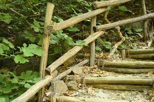 old homemade wooden staircase that runs over rocks in a mountain gorge photo