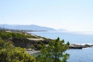 hermosa laguna azul con agua de mar clara y una playa de guijarros y rocas foto