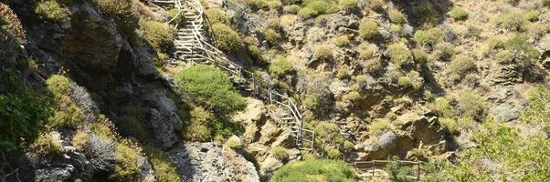Antigua escalera de madera casera que atraviesa rocas en un desfiladero de montaña foto
