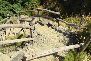 Old homemade wooden staircase that runs over rocks in a mountain gorge photo