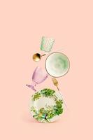 Contemporary still life composition with balancing dishes on pale pink background photo