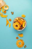 Package with assorted vegan jerky, bowl on blue background photo