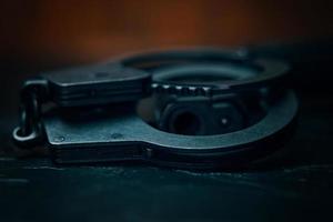 Handcuffs and the muzzle of a handgun close-up photo