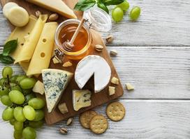 Various types of cheese on a white wooden background photo