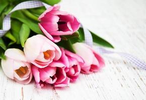 Bouquet of pink tulips on an old wooden background photo