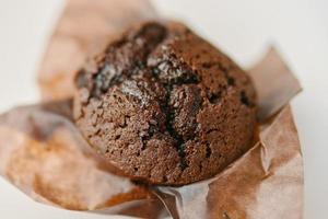 Cupcake with dark chocolate in paper wrapper photo