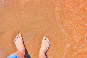 Man's feet on the beach photo
