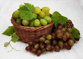 Grapes with leaves on an old wooden background photo