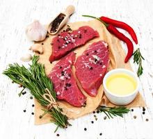 Fillet of beef and ingredients on an old wooden background