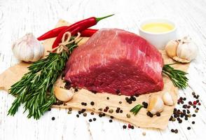 Fillet of beef and ingredients on an old wooden background photo