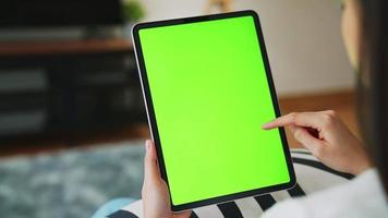 mujer sosteniendo una tableta con pantalla verde video