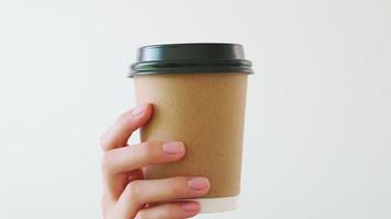 main tenant une tasse de café en papier brun video