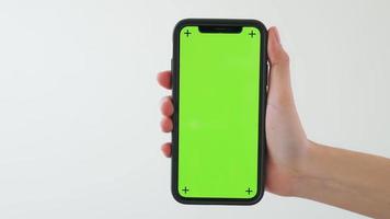 main tenant un smartphone avec écran vert video