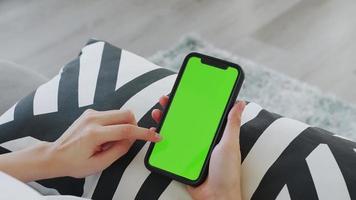 mulher segurando smartphone com tela verde video