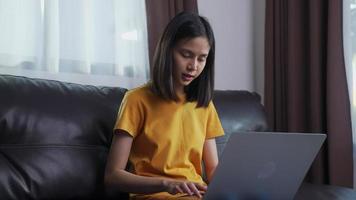 mulher sentada no sofá digitando video