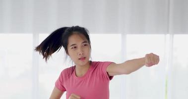 femme asiatique boxe dans son appartement