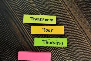 Transform your thinking written on small notes isolated on wooden table photo