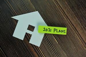 2021 plans homemade by paper written on sticky notes isolated on wooden table photo