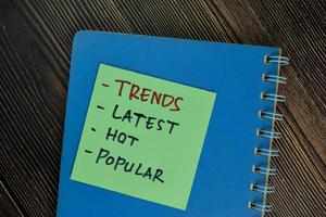 Trends, latest, hot, popular- words written on sticky notes isolated on wooden table photo