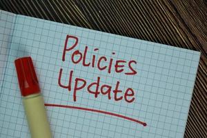 Policies update written on sticky notes isolated on wooden table photo