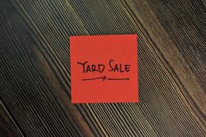 Yard sale written on sticky notes isolated on wooden table photo