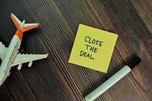 Close the deal written on sticky notes isolated on wooden table photo