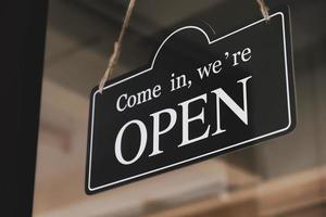 Open sign hanging on the glass door of a small business shop photo