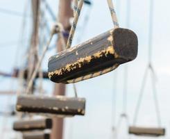 Small wooden logs suspended by ropes photo