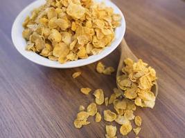 Corn flakes and bowl on wood table photo