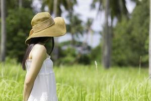 mujer con un vestido blanco de pie en el jardín foto