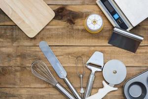 Bakery and cooking tools with kitchen timer and scales on a wood table photo