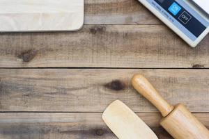 Herramientas de panadería de madera con una balanza digital sobre una mesa de madera foto