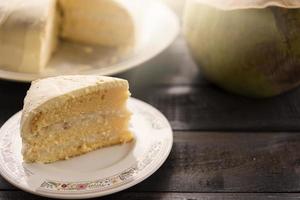 Coconut cream cake with coconut fruit on a wooden background photo