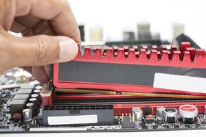 Close up of hand installing a high-performance DDR3 RAM into a motherboard photo