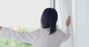 Frau öffnet die Vorhänge in ihrem Schlafzimmer video