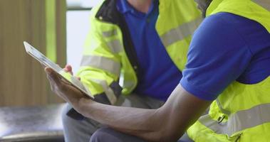 Deux hommes discutant de la stratégie à l'aide d'une tablette au travail video