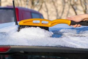 Removing snow from a car roof photo