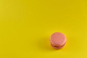 Pink macaroon on a yellow background photo